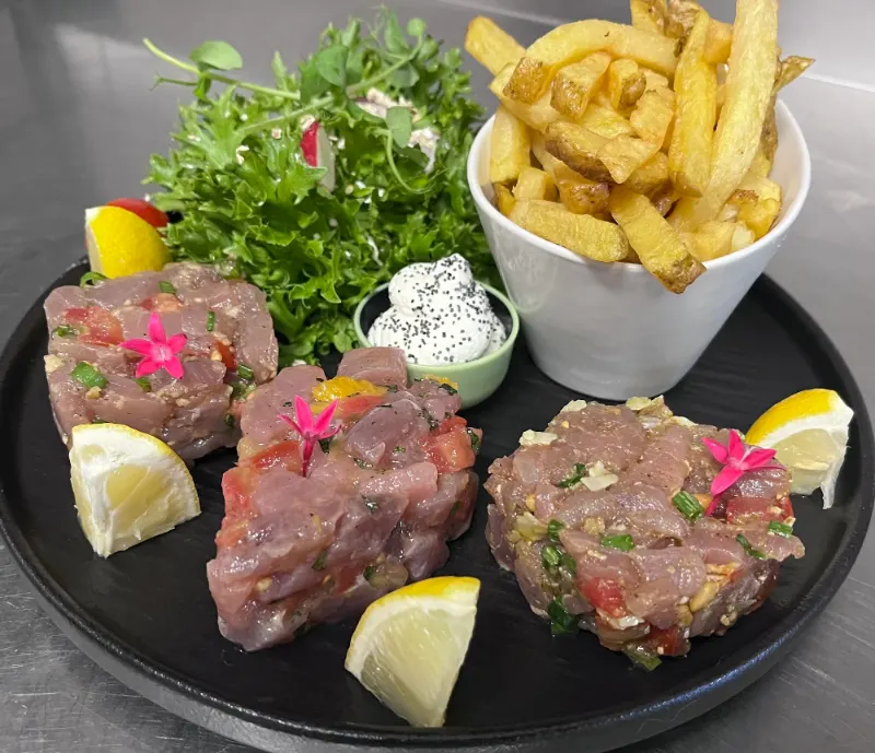 Un trio de tartares servi avec des frites maison et une salade.